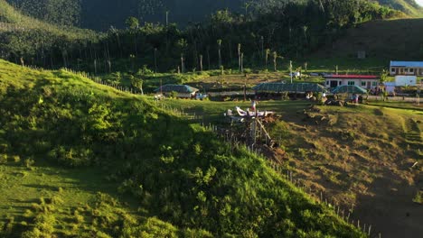 vacationist standing on huge hand sculpture and waving at drone camera in a private resort by the mountain in the philippines