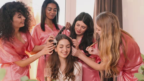 Group-Of-Multiethnic-Female-Friends-Making-Up-And-Combing-The-Bride-In-Bridal-Gathering