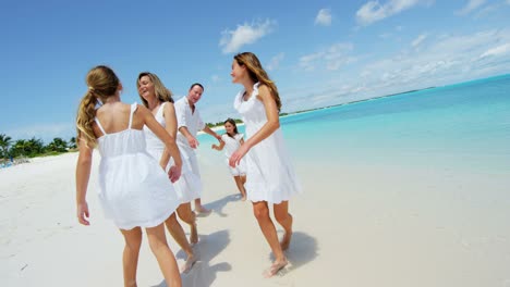caucasian family together on beach by tropical ocean