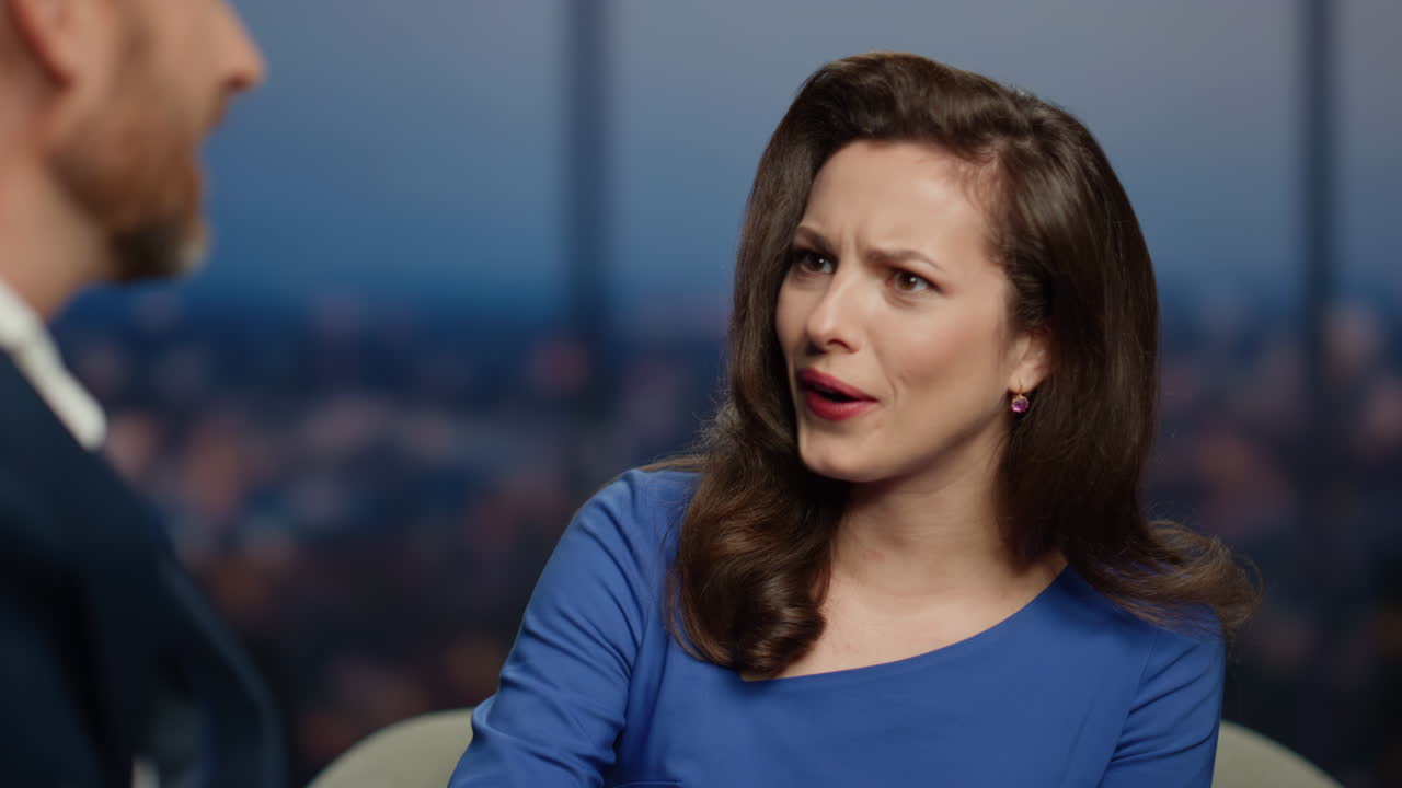 áncora expresiva presentando un programa de televisión con celebridades invitadas en el estudio de cerca.