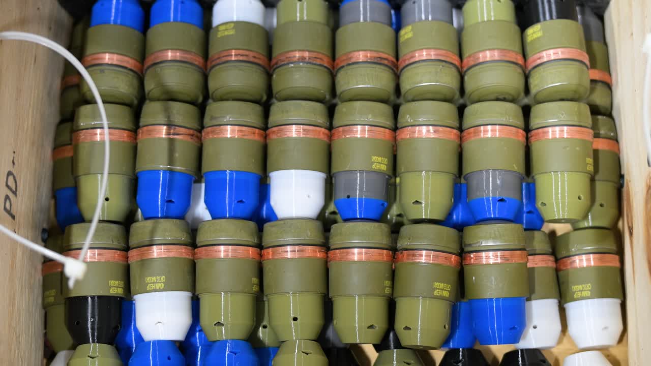 Colorful, modified grenades with plastic casings, destined for military drones, fill a box at a workshop in Ukraine's Donetsk region. Adaptive weapon tech for modern warfare