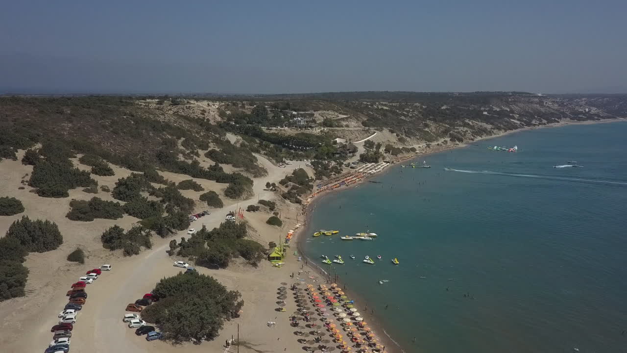Rock outcrop aerial reveals Water Club Paradise Beach on Kos, Greece