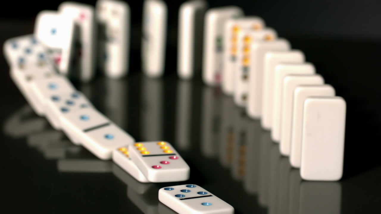 Finger pushing over colourful dominoes