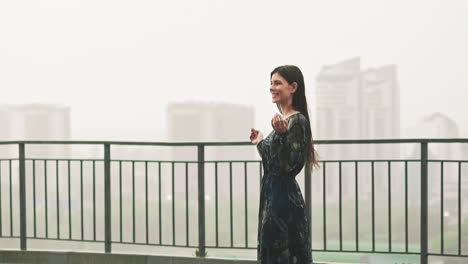 Cheerful-lady-wearing-wet-clothes-enjoys-falling-rain