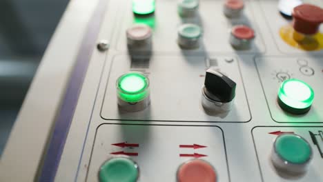 primer plano de un panel de control industrial con botones y luces