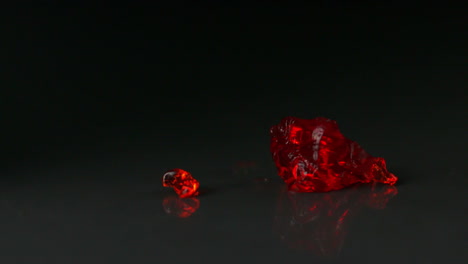 red jelly falling and bouncing on black background