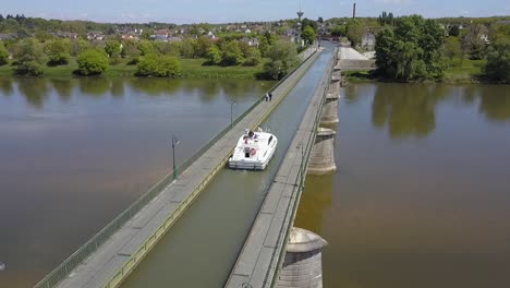 Aerial-view-of-a-boat-crossing-the-aqueduct-at-Briare,-France,-Europe