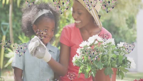 Animation-of-hearts-over-smiling-african-american-mother-and-daughter-gardening-plants