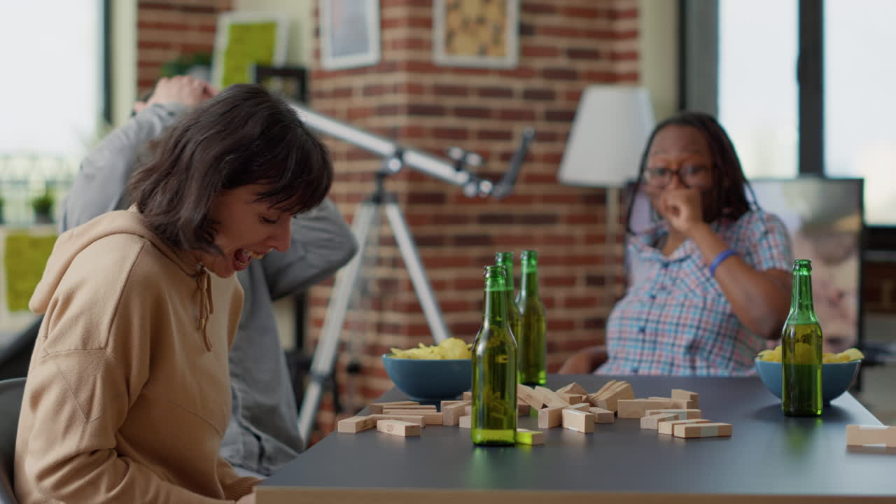 Young woman crashing building tower with wooden pieces