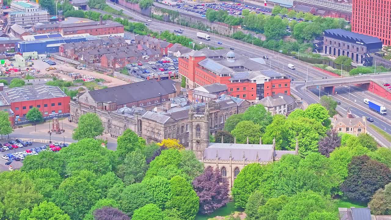 Bird's eye view of Woodhouse Street area in Stoke, UK, showing mixed old and modern architecture, tree lined streets, parks and a connected road network on a summer day