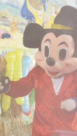 mickey mouse mascot entertaining at a disney-themed event with cartoon characters and balloons