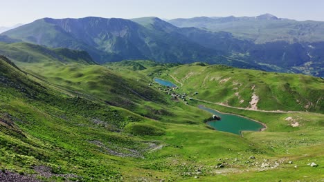 mountain scenery aerial – nature green meadows of valleys with lakes and village in summer