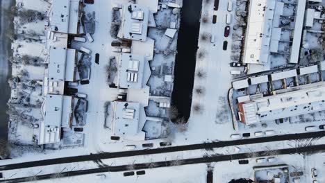 top down aerial of a beautiful street with homes covered in snow