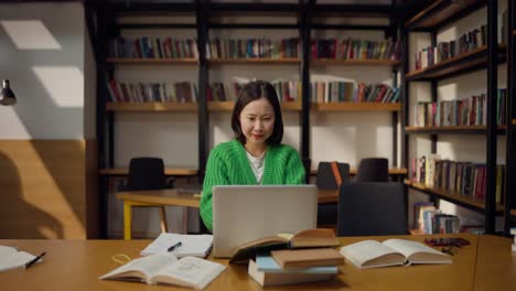mujer feliz estudiando en una biblioteca