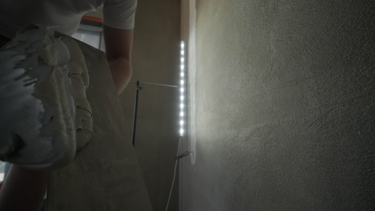 Applying plaster to a wall with a finishing trowel, a skilled task in the process of wall smoothing for painting or wallpapering in construction and renovation