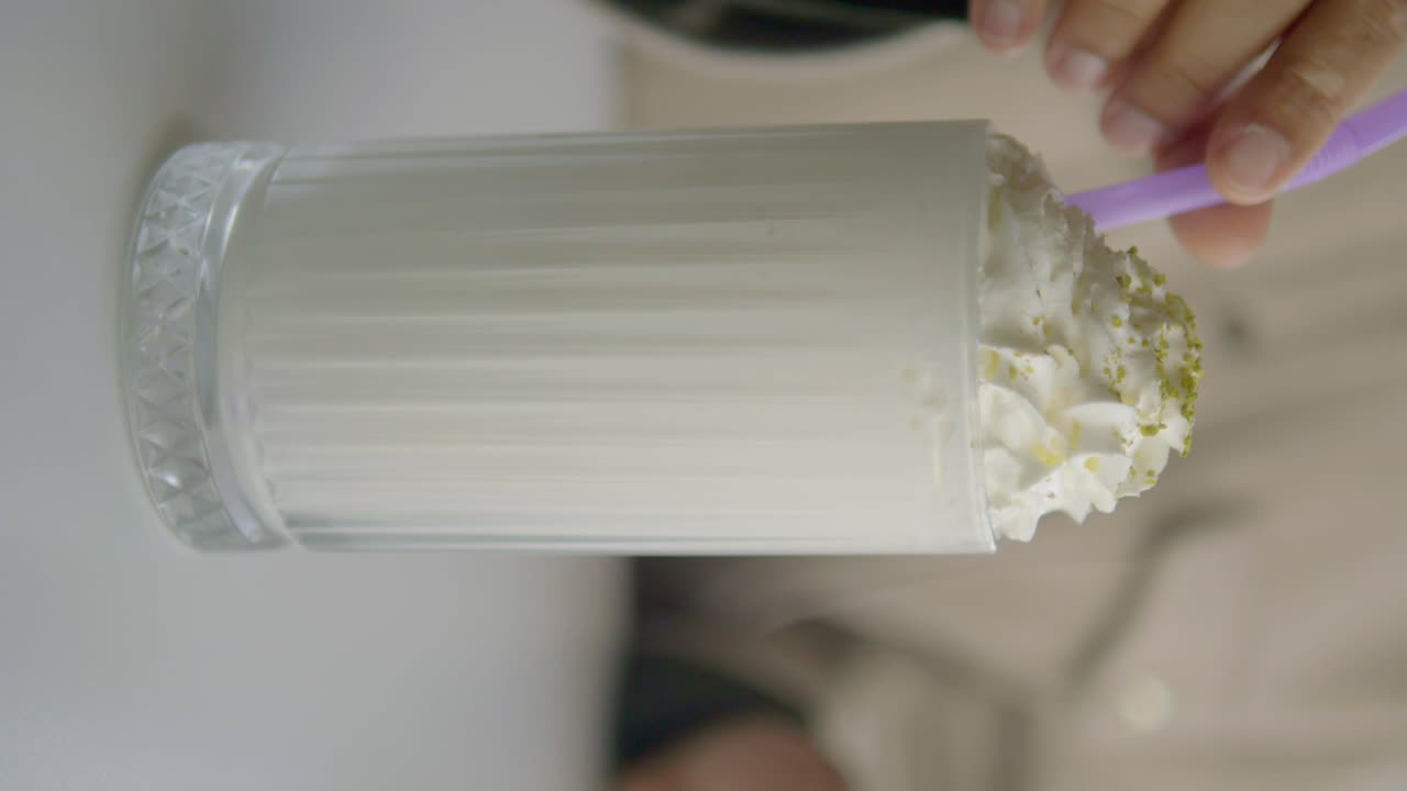 Person Drinking a Creamy Milkshake