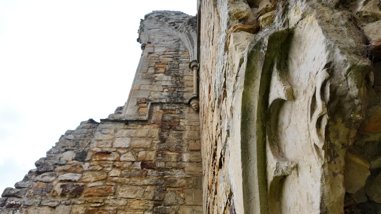 Close-up of intricate stonework at Old Bayham Abbey, Kent. Detailed medieval carvings and textures highlight historic craftsmanship, ideal for heritage, architecture, or cinematic projects