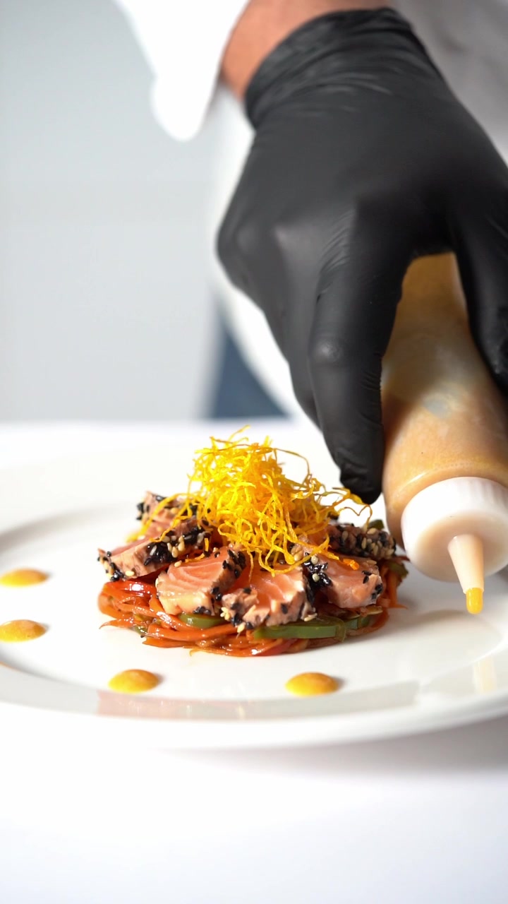 Kok anretter sauce på en gourmetret med grøntsager og kød i minimalistisk stil, nærbillede, indskudsbillede.