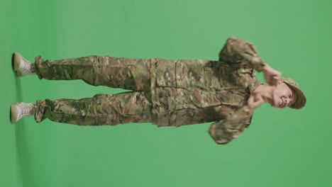 full body of asian man soldier dancing while standing in the green screen background studio