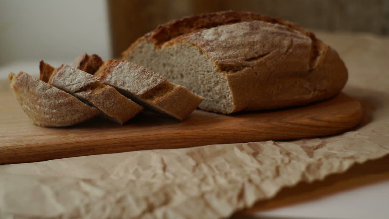 Sliced bread on cutting board at kitchen. Closeup of homemade bread slices