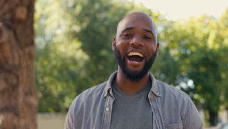 portrait of laughing man standing outdoors in garden park or countryside