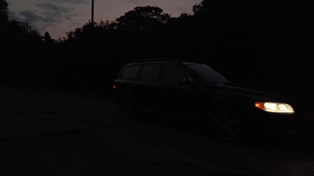 Car slowly driving toward with head lamps on at night
