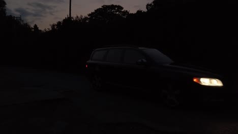 car slowly driving toward with head lamps on at night