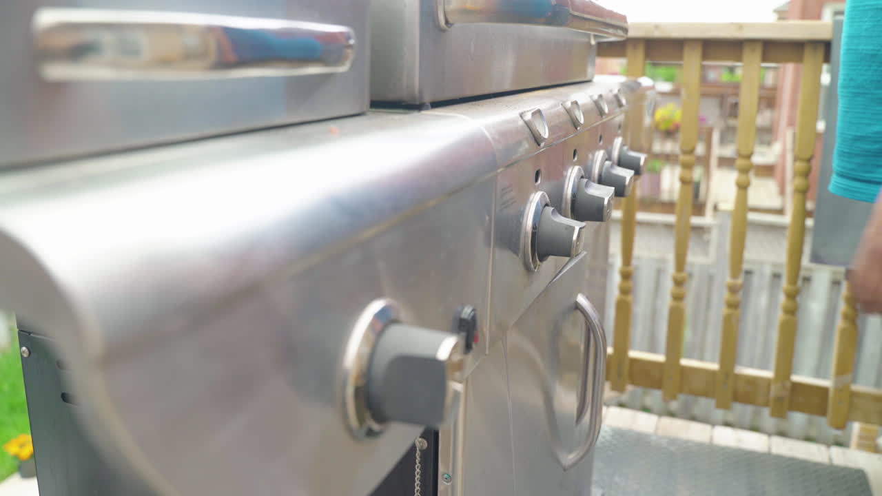 mano alcanzando y encendiendo la barbacoa