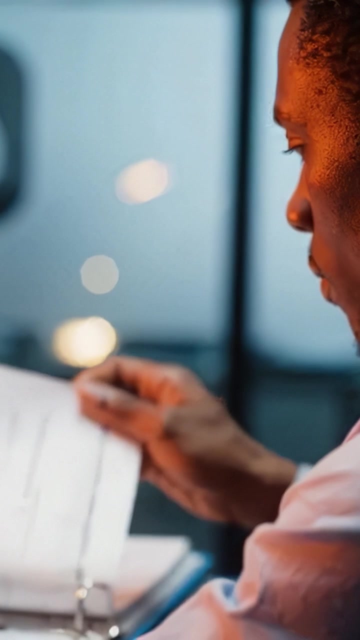 Focused individual deeply engaged in work, illuminated by soft ambient light, showcasing concentration and creativity in a serene environment with hints of bokeh.