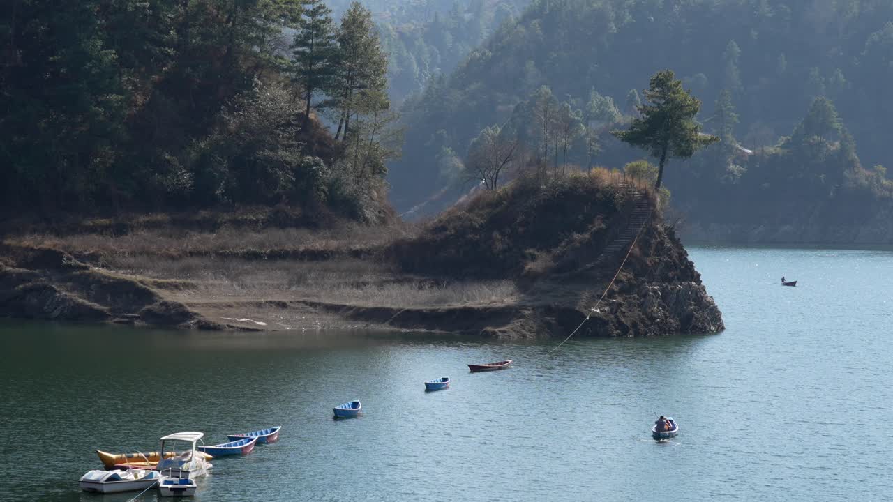 una vista de ángulo alto de un pequeño bote de remos en el lago kulekhani en nepal tomando turistas en un recorrido por el lago