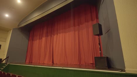 empty red seats in thalia theatre with yellow lights and big red curtain