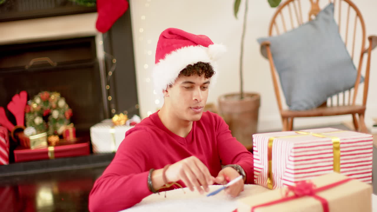 hombre biracial envolviendo un regalo de navidad en papel decorativo, cámara lenta