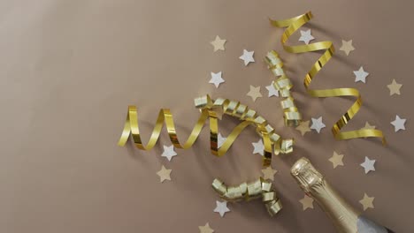 Champagne-bottle-with-decorations-and-stars-on-green-background-at-new-year's-eve