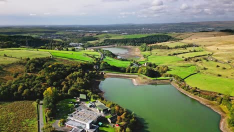 Aerial-drone-footage-taken-near-Saddleworth-moor-Oldham,-of-a-series-of-Lakes,-Reservoirs,-set-against-a-backdrop-of-moorland-and-woodlands