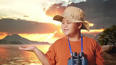 asian boy with a hat and binoculars smiling and pointing to side at a lake. boy researcher examines something, travel tourism adventure concept, close up