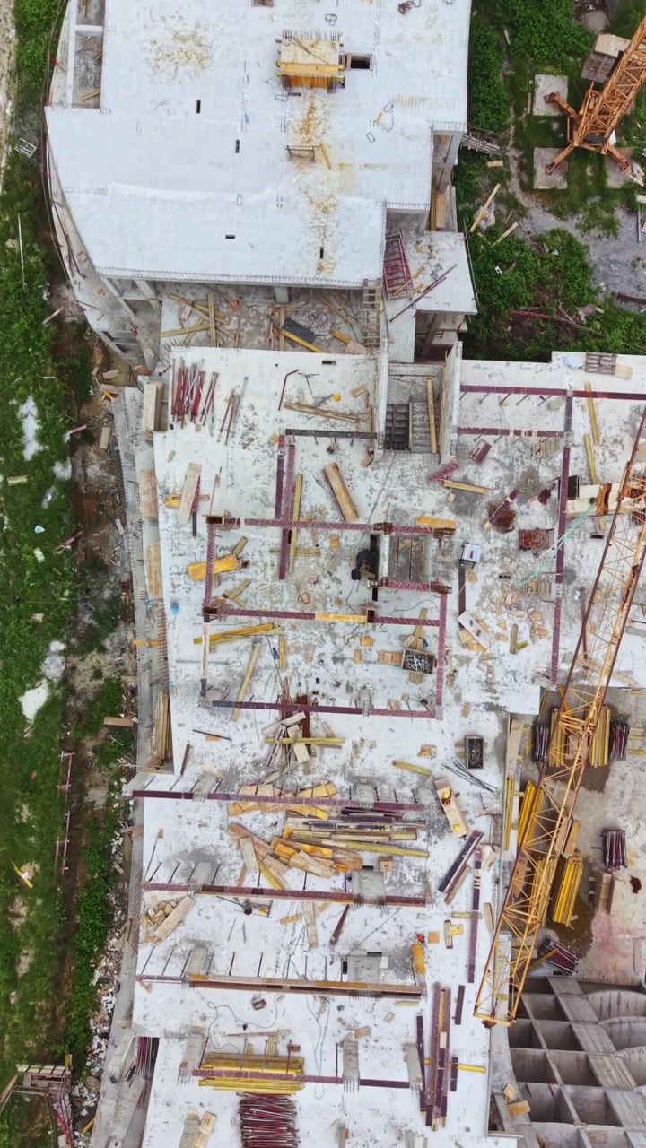 Proceso de construcción de un edificio de varias plantas en una zona urbana con diversos materiales y herramientas visibles