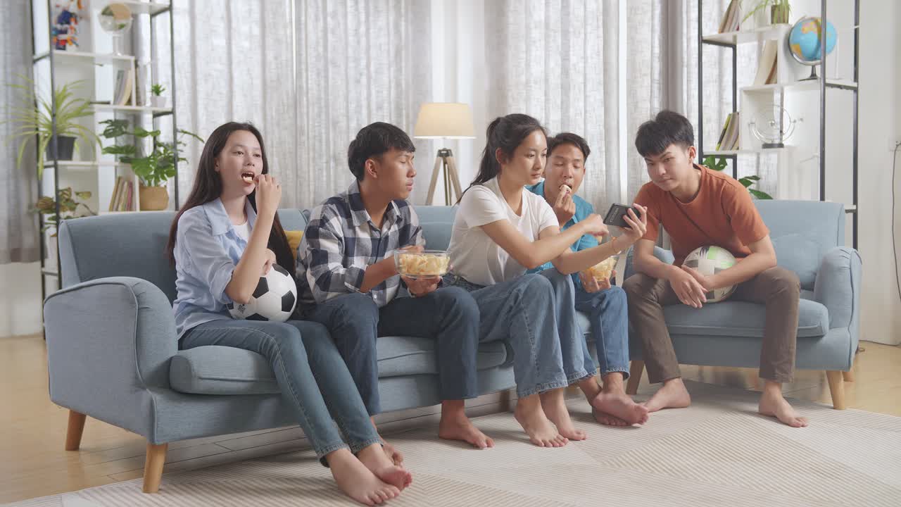 친구 들 이 집 에서 축구 경기 를 보고 있다