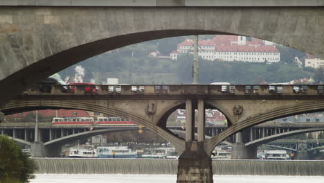 view to bridges over the vlatava river in prague with traffic of cars and tram passing