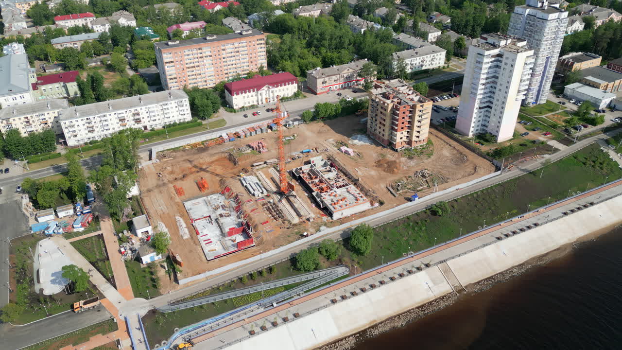 Aerial View of a Construction Site Alongside a River in an Urban Area