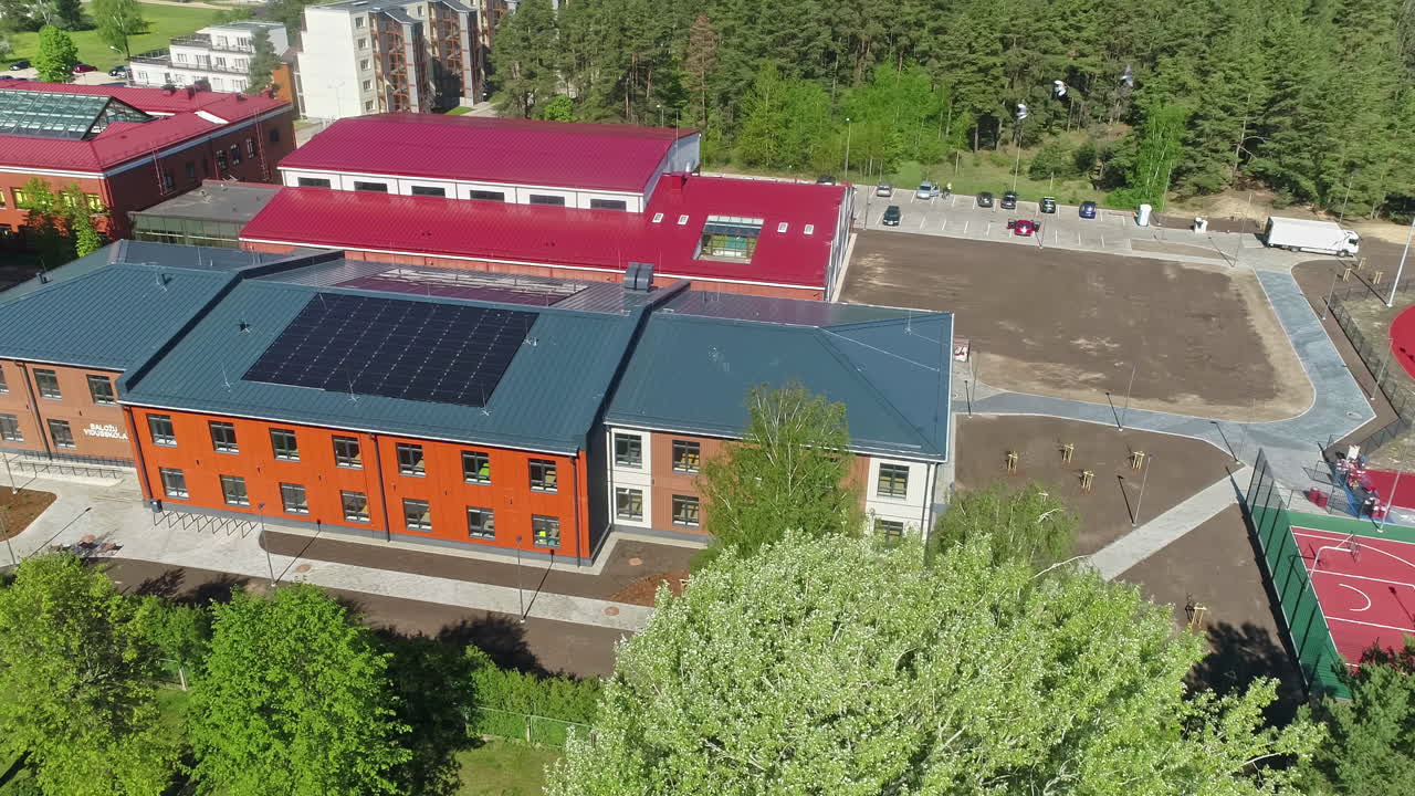 вид с воздуха на солнечные батареи на крыше школы