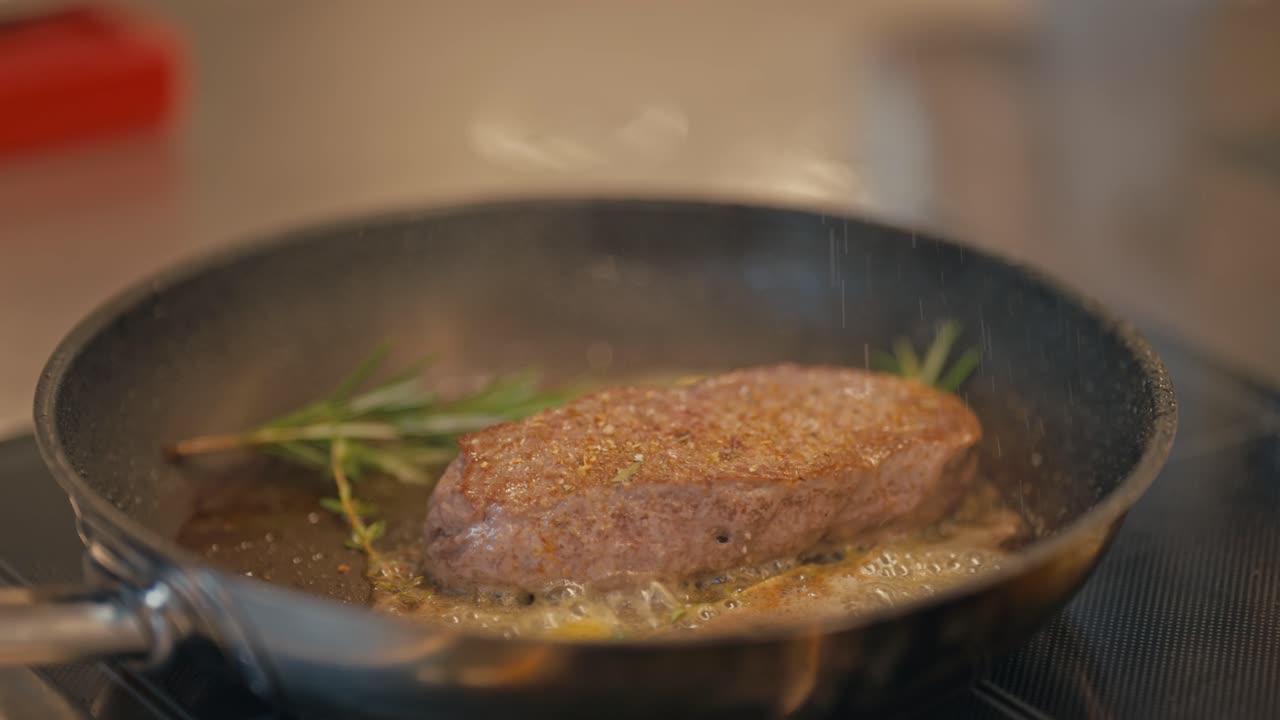 Chef seasoning delicious steak in hot pan, close up view