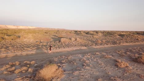 young man running in the desert landscape