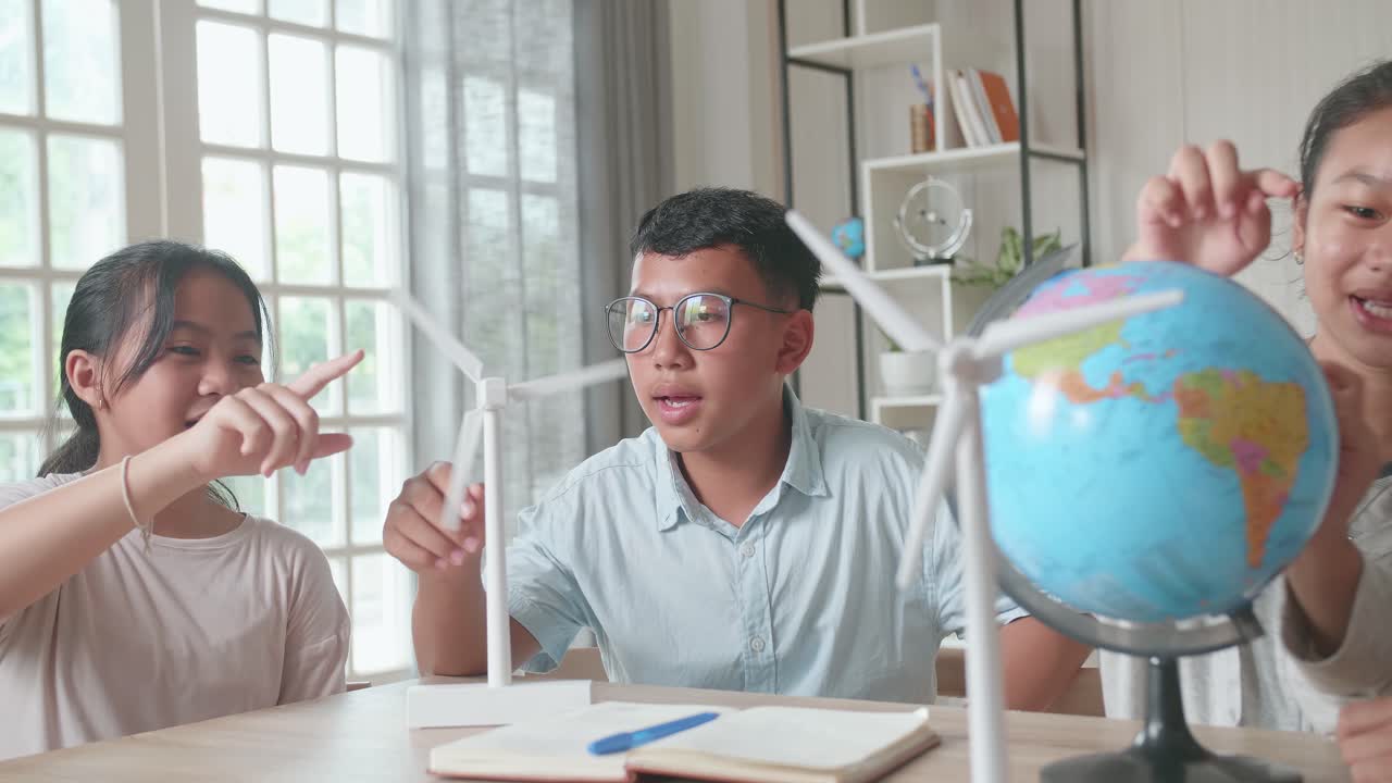 Asian Group Of Thoughtful Kids Study About Ecology Problems And Their Solution With Wind Turbine Model And Globe At School. Renewable Energy
