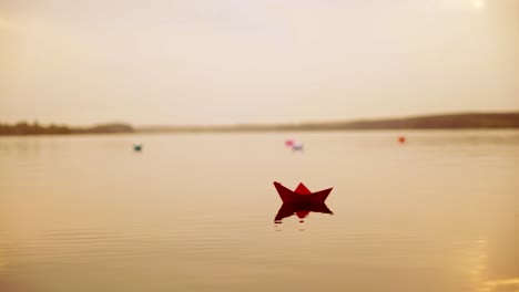 paper boats floating in the river. beautiful summer sunset. origami.