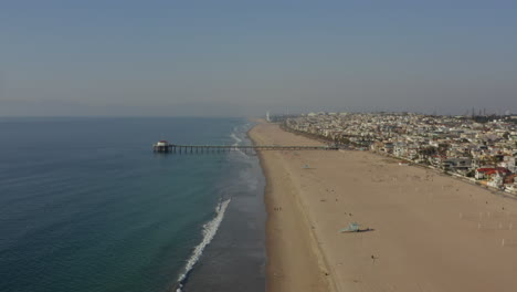 Antenne:-Menschen-An-Den-Strandwellen,-Wasser-Mit-Pier-In-Los-Angeles,-Kalifornien,-Sonnig,-Blauer-Himmel