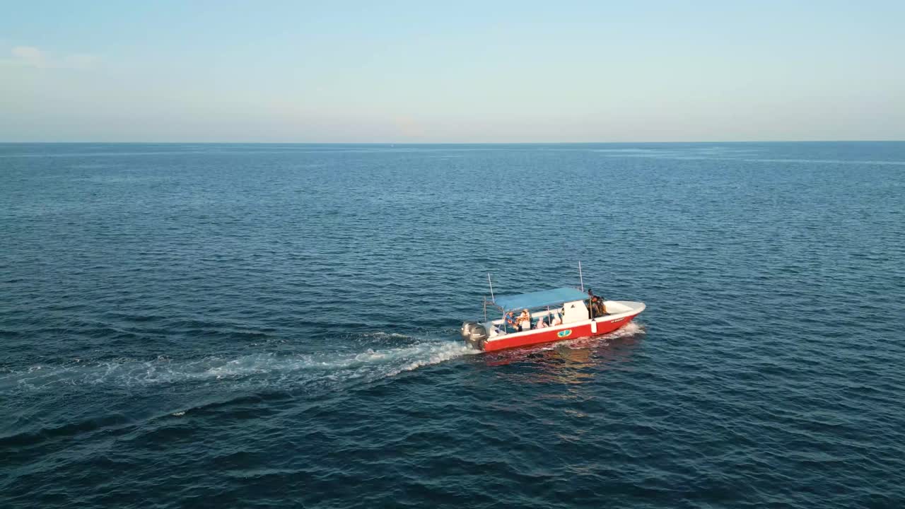 해가 지는 동안 배가 조용한 물을 통해 서두르지 않고 여행하는 바다 풍경의 조용한 아름다움을 공중에서 포착합니다. 장소는 말레이시아 사바 셀베스입니다.