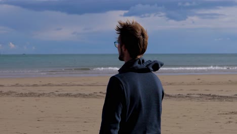 lone male strolling along a sunny beach, bathed in warm, golden light of perfect day