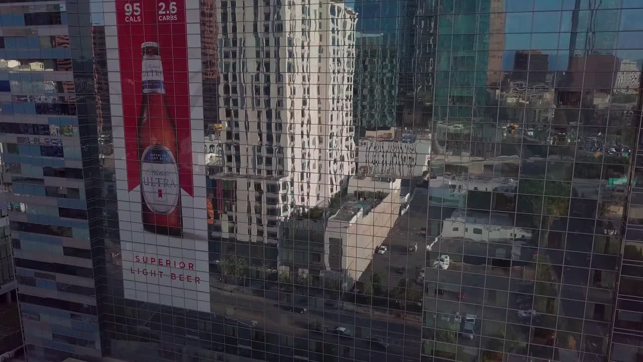 Aerial bird's eye close up rising shot of a reflective glass hotel. 4K