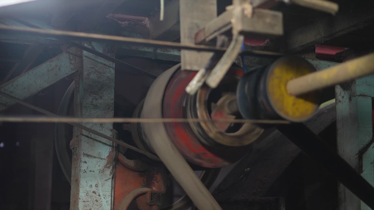 Close-up of industrial machinery with moving belts and pulleys