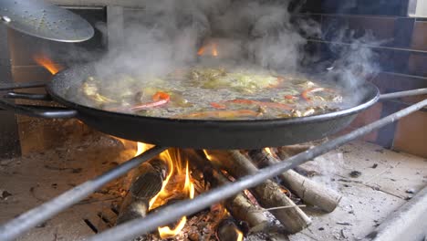 cocinar una paella en un fuego abierto con mucho humo